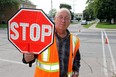 A Stratford crossing guard holds up a stop sign. (Postmedia Network file photo)