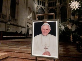 A portrait of Pope Emeritus Benedict XVI is seen near the altar at the Cathedral of Regensburg, southern Germany, on Dec. 29, 2022, during a mass. Former pope Benedict XVI remains in serious but stable condition, Italian media reported on Dec. 29, the day after the Vatican revealed the 95-year-old's health had deteriorated. (Photo by FLORIAN CAZERES/AFP via Getty Images)