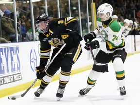 London Knights' Jacob Julien (74) checks Sarnia Sting's Ryan Mast (3) at Progressive Auto Sales Arena in Sarnia on Dec. 30, 2022. (Mark Malone/Postmedia Network)