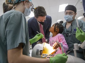 Four-year-old Amanda Ibeya throws a perturbed look at Prime Minister Justin Trudeau after he interrupted her while she was playing with dental student tools at Western University's Schulich school of medicine and dentistry in London on Thursday, Dec. 1, 2022. Trudeau was there to make an announcement about the new federal Canada Dental Benefit for children under 12. (Derek Ruttan/The London Free Press)