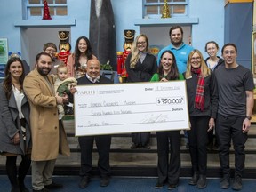 London Children's Museum executive director Kate Ledgley accepts a giant cheque in the sum of $750,000 from Shmuel Farhi in London on Thursday, Dec. 8, 2022. Derek Ruttan/The London Free Press
