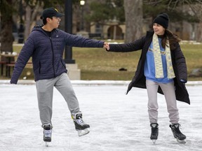 Miguel Ostia and Andrea Prete skate on opening day of the ice rink at Victoria Park in London on Monday December 12, 2022. (Derek Ruttan/The London Free Press)