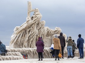 People check out the ice that has formed on the pier in Port Stanley on Monday, Dec. 26, 2022.  Dozens of people travelled to the lakeside community to see the pier in the wake of a storm that send temperatures plunging and winds roaring in off the lake. Derek Ruttan/The London Free Press
