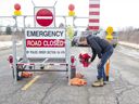 Tim Ferguson places flowers at the scene while police investigate the slaying of an OPP officer on Indian Line at Objiwa Road west of Hagersville on Wednesday December 28, 2022. Derek Ruttan/The London Free Press/Postmedia Network