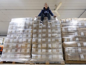 Allison DeBlaire of 519 Pursuit sits atop a pile of about 35,000 socks donated to their effort to collect them for homeless Londoners. (Mike Hensen/The London Free Press)