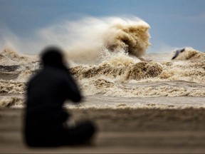 John Park of London settles down with a long lens to photograph big waves in Port Stanley amid strong winds on Wednesday Nov. 30, 2022. Central Elgin and the federal government announced $17 million in storm surge protection funding Monday, Jan. 16, 2023. (Mike Hensen/The London Free Press)
