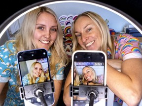 Sarah Couvillon and Rachael Newby, founders of Rainbow Certified, are framed in their ring light they used for their viral videos on TikTok. The London online business sells Pride merchandise to people in dozens of countries, and Couvillon and Newby have a massive online following on Tik Tok and other social media. Photograph taken on Wednesday, Dec. 21, 2022. (Mike Hensen/The London Free Press)