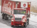 A trucker tries to maintain control as his big rig slides down the westbound lanes of the icy Hwy.  402 on Friday December 23, 2022. Mike Hensen/The London Free Press/Postmedia Network