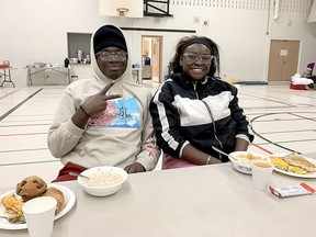 Brother and sister Kelvin and Shannah Antwi of Cincinnati  were among the 60 travellers stranded in Friday's massive winter storm that found shelter at Chatham Christian school. Here they enjoy breakfast on Saturday, Dec. 24, 2022. Ellwood Shreve/Chatham Daily News