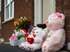A memorial of teddy bears, candles, flowers and children's drawings continues to grow on the front steps of a townhouse unit on Boullee Street, where London police discovered two dead people on Saturday Dec. 10, 2022. (Calvi Leon/The London Free Press)