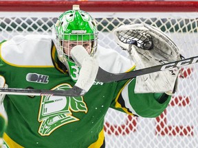 London Knights goalie Brett Brochu catches the puck despite tip attempts by two Hamilton Bulldogs players during the first period of their OHL game at Budweiser Gardens in London on Friday January 6, 2023. Derek Ruttan/The London Free Press/Postmedia Network