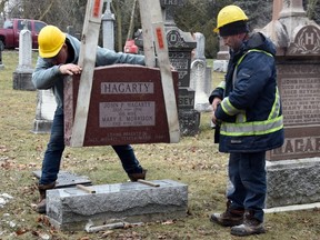 John Ibbotson, left, and Carl Olsen of Kitchener's Stone Centre were on hand Monday to help clean up and restore the headstones that were vandalized at the St. Vincent de Paul cemetery in Mitchell on Jan. 3. The OPP has announced seven teenagers, ranging in age from 13 to 17, have been charged with mischief. (ANDY BADER/Postmedia Network)