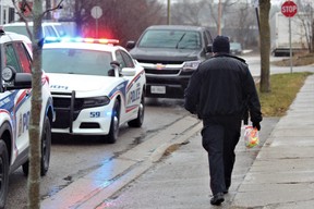 A London police officer carries a bag of evidence following a break-in and stabbing on Paddington Avenue on Tuesday, Jan 3, 2023. (Dale Carruthers/The London Free Press)