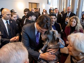 Prime Minister Justin Trudeau hugs Tourane Shamsolahi, the relative of victims, at an event marking the the third anniversary of the downing of Ukraine International Airlines flight PS752, which was shot down near Tehran by Iran's Revolutionary Guards, in Toronto, Sunday, Jan. 8, 2023.