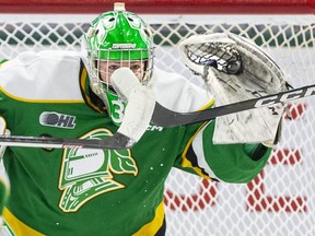 London Knights goalie Brett Brochu catches the puck despite tip attempts by two Hamilton Bulldogs players during the first period of their game at Budweiser Gardens in London on Saturday January 7, 2023. (Derek Ruttan/The London Free Press)