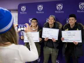 Samantha Munro of Western student experiences photographs Austin Huang, Ivan Ye and Johnny Lum of Western as they hold their thought bubbles at Bell Let's Talk Wednesday January 31, 2018 at the wellness education centre. The student centre was handing out 750 bright blue Bell toques to students who posed with their thoughts of mental health as a show of support to those with mental health issues and to end the stigma associated with mental health. (Mike Hensen/The London Free Press)