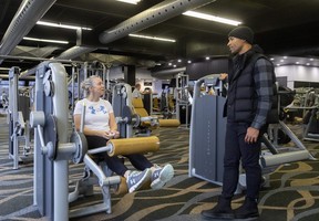 Damian Warner, right, chats with Kerry Scrivens as she works out on Monday, Jan. 2, 2023, at the fitness club at 755 Wonderland Rd. now named after the London Olympian. London developer Southside Group has opened Damian Warner Fitness Centres in two former Movati clubs that were closed in the summer. (Mike Hensen/The London Free Press)