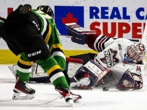 Ryan Humphrey of the London Knights tries to get his stick on a loose puck in front of Guelph Storm goalie Patrick Leaver who manages to cover up in the dying seconds of the first period at Budweiser Gardens in London on Friday, Jan. 13, 2023. (Mike Hensen/The London Free Press)