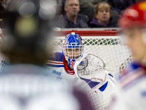 Ryan Humphrey of the London Knights can only watch as goalie Marco Costantini of the Kitchener Rangers keeps his eye on a shot through traffic in their OHL game at Budweiser Gardens in London on Jan. 22, 2023. (Mike Hensen/The London Free Press)