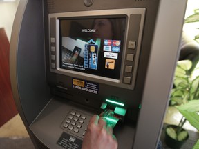 A person uses a bank machine in this file photo