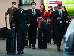 Cathay Pacific crew members who worked on a flight from Hong Kong arrive at Vancouver International Airport, in Richmond, B.C., on Wednesday, January 4, 2023. The Canadian government announced last week that the travellers would need a negative test administered within 48 hours of their departure as cases soar in China.