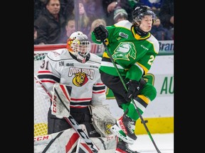 London Knights player Ryan Humphrey takes a painful shot of the shin while screening Owen Sound Attack goalie Nick Chenard during their game at Budweiser Gardens in London on Friday January 20, 2023. Derek Ruttan/The London Free Press/Postmedia Network
