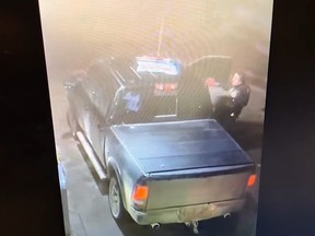 This screengrab is from a Stratford police video showing an officer wrestling with a man beside a pickup truck shortly before it pulls away, dragging him and almost running him over.