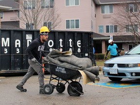 A disposal crew member hauls damaged items from the fire-ravaged Fairwinds Lodge retirement home in Sarnia on Wednesday, Jan. 18, 2023. (Terry Bridge/Postmedia Network)