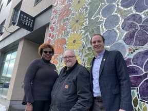 Standing in front of the murals at newly opened Indwell Embassy Commons are program supervisor Camille Nelson, left, resident Shawn Russwurm and Indwell chief executive Jeff Neven. The 72-unit building serving some of the city’s most vulnerable was officially opened on Tuesday, Feb. 28, 2023. (JANE SIMS/The London Free Press)