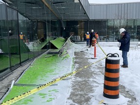 City workers assess the damage to the East Lions community centre on Saturday Feb. 25, 2023 after part of the soffit and roof collapsed outside of the north entrance of the building. (Jennifer Bieman/The London Free Press)