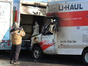 A U-Haul employee photographs damaged trucks at the company’s depot at 745 York St. in London, where a suspicious fire early Wednesday destroyed six vehicles and damaged several others. (Dale Carruthers/The London Free Press)