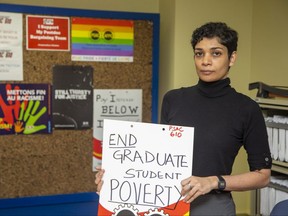 Karuna Dsouza, president of the graduate teaching assistant and postdoctoral associate union at Western University, holds a protest sign on Monday Feb. 6, 2023 in London. The union will be holding a rally in support of better wages for its members on Tuesday. (Derek Ruttan/The London Free Press)