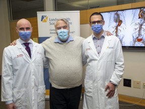 Jeff Pitman says he owes his life to vascular surgeons Luc Dubois, left, and John Landau who repaired an aortic dissection with a stent graft they had to get special permission from Health Canada to use. The operation was performed at London Health Sciences Centre. Photograph taken in London on Tuesday, Feb. 7, 2023. (Derek Ruttan/The London Free Press)