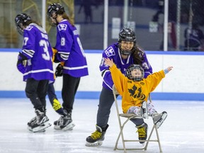 Four-year-old Emily Jennings spreads her wings and flies along the ice thanks to a push from Western Mustangs hockey player Emma Thomas at Thompson Arena in London on Thursday February 9, 2023. Several members of the team helped out during the Thames Valley District school board's annual event for blind and partially sighted students. (Derek Ruttan/The London Free Press)