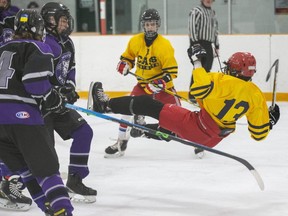 Tyrese Morgan of the College Avenue Knights goes airborne after colliding with Tyler Sweeney of the West Elgin Wildcats in a TVRA boys hockey game at West Lorne Arena in West Lorne on Friday, Feb. 10, 2023. (Derek Ruttan/The London Free Press)