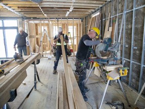 Carpenters John McDermott, left, Micah Friedel and Lonnie Van Horn of CCR Build and Remodel work on a home on Piccadilly Street in London that is more than 100 years old on Tuesday, Feb. 28, 2023. (Derek Ruttan/The London Free Press)