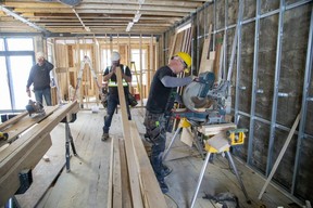 Carpenters John McDermott, left, Micah Friedel and Lonnie Van Horn of CCR Build and Remodel work on a home on Piccadilly Street in London that is more than 100 years old on Tuesday, Feb. 28, 2023. (Derek Ruttan/The London Free Press)