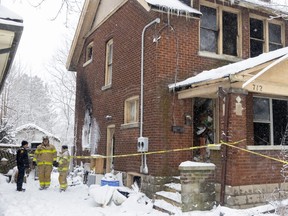 London firefighters are shown outside 712 Adelaide St. N. in London on the morning of Friday Feb. 3, 2023. The house was stuffed full of debris, one factor that made it difficult for fire crews to get inside when a blaze broke out around 3:30 a.m. Damage was pegged at $400,000. (Mike Hensen/The London Free Press)