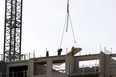 A crane lowers a slab at a 14-storey Tricar tower being built at 309 Southdale Rd. in Westmount Estates in London on Wednesday, Feb. 8, 2023. The London region added 1,700 jobs in January, lowering the unemployment rate to five per cent. (Mike Hensen/The London Free Press)