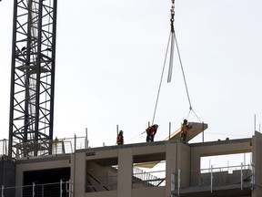 A crane lowers a slab at a 14-storey Tricar tower being built at 309 Southdale Rd. in Westmount Estates in London on Wednesday, Feb. 8, 2023. The London region added 1,700 jobs in January, lowering the unemployment rate to five per cent. (Mike Hensen/The London Free Press)