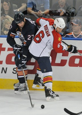 Dustin Penner of the Edmonton Oilers manages to maintain control while being checked by Dennis Wideman of the Florida Panthers at Rexall Place in Edmonton on Oct. 10, 2010. (SHAUGHN BUTTS/Postmedia Network)