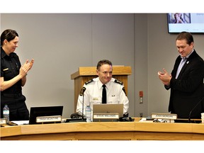 Deputy police chief Trish McIntyre, left, and Mayor Josh Morgan, right, applaud Chief Steve Williams, centre, after he gave his final address to the city's police board on Thursday, Feb. 16, 2023. Williams' last day on the job is Feb. 24. (Dale Carruthers/The London Free Press)