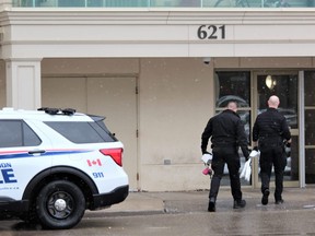 London police forensic investigators enter an apartment building at 621 Kipps Lane last Sunday. A London man is charged with second-degree murder and two counts of attempted murder after a man was found dead at the building and two police officers were shot during a standoff with an armed suspect, police say. (Dale Carruthers/The London Free Press)