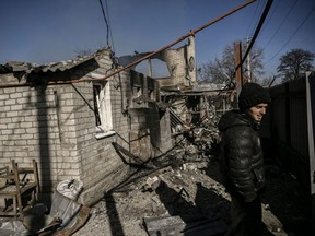 A man stands in front of a house destroyed by shelling in the village of Chasiv Yar near Bakhmut, on March 14, 2023.  (Photo by ARIS MESSINIS/AFP via Getty Images)
