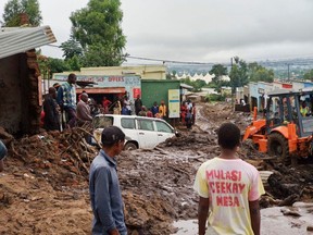 People look on as an excavator digs through the mud in search for bodies in the township of Manje in Blantyre on March 16, 2023. As the rains ceased for the first time in five days, Malawi began the process of recovering bodies from cyclone Freddy-induced mudslides.
A joint operation by the military and members of the local communities recovered five bodies on March 16, 2023 from the mud. (Photo by JACK MCBRAMS/AFP via Getty Images)