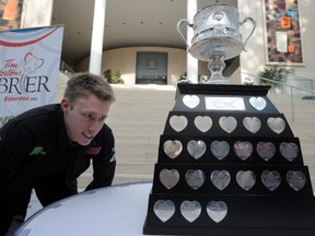 Marc Kennedy checks out his name on the trophy from when he won it in 2008 and 2009 at the Tim Hortons Brier press conference at city hall in Edmonton, Feb. 11, 2013. (Bruce Edwards/Postmedia Network)