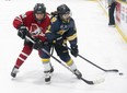 Hayley Waters of the Strathroy District Saints is checked by Kelly Hubert of the Medway Cowboys during game two of the TVRA Central Thames Valley AAA girls hockey final at Kinsmen Arena in London on Thursday, March 2, 2023. The Saints tied the series at one win apiece with a 2-1 win to force a third and final game Monday. (Derek Ruttan/The London Free Press)