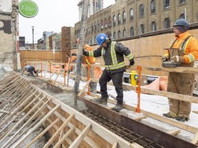 Chris Fidler and Ben Braun pour concrete on York Street in downtown London on Thursday, March 16, 2023. A Conference Board of Canada forecast predicts slower growth for the city due to inflation and interest rate increases. (Mike Hensen/The London Free Press)