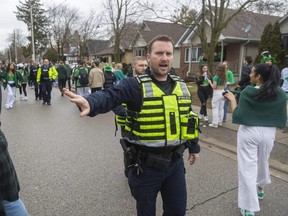 London police clear the crowds off Broughdale Avenue after more than a 1,000 students gathered to celebrate St. Patrick's Day on Friday, March 17, 2023. (Mike Hensen/The London Free Press)