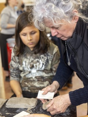 Artist Susan Day shows Derek how a tile can be stamped using a mold.  Derek's family has been directly affected by drug use and overdose.